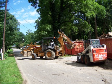 Backhoe loading debris after flood