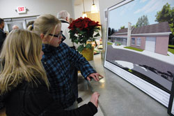 St. Jude School students and sisters Allison Lewis, left, and Caitlyn Lewis of Indianapolis look at an architectural drawing of the new parish youth center during a Dec. 12 open house. Caitlyn is a sixth-grade student and Allison is a fourth-grader. (Photo by Mary Ann Wyand)