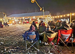 Bundled up for snow and temperatures in the teens, worshippers pray during an outdoor midnight Mass on Dec. 25, 2020, on the St. John the Baptist campus of All Saints Parish in Dearborn County. In order to accommodate more worshipers than would be allowed indoors, the Batesville Deanery faith community has celebrated Sunday and holy day Masses outside during the coronavirus pandemic. (Submitted photo)