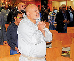 Franciscan Friars of the Renewal Father Agustino Torres prays in a pew before delivering a keynote address at the National Black Catholic Men’s Conference at St. Rita Church in Indianapolis on Oct. 13. (Photo by Mike Krokos)