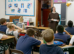 Sister Mary John Pultorak, OSF, teaches students at St. Boniface School during her recent service in Lafayette. At right: Joy Bosma, Andrew Boggess and Elizabeth Buczkowski show some of the handmade booklets about the corporal and spiritual works of mercy. (Photos by Caroline B. Mooney)