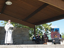 “Let us summon the 9/11 spirit of unity to confront our challenges,” urged Father Patrick Baikauskas, OP, pastor of St. Thomas Aquinas Parish, West Lafayette. At right in the photo, artist Stacy Bogan creates a painting depicting the aftermath of the 9/11 attacks in New York City. (Photos by Caroline B. Mooney)